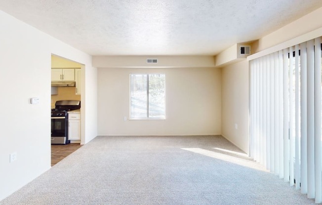an empty living room with white walls and windows