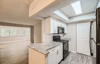 A kitchen with a granite countertop and white cabinets.