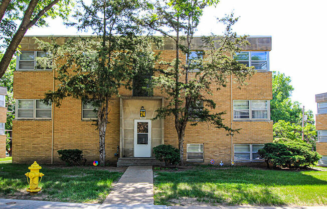 a brick building with a white door and a yellow fire hydrant in front of it