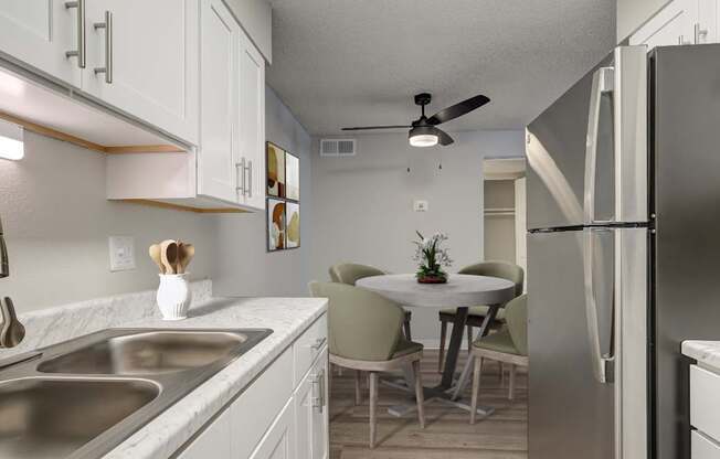 A kitchen with a table and chairs in the middle.
