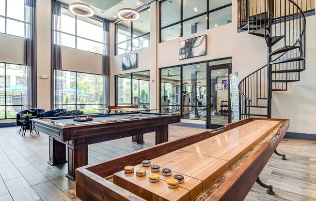 a game room with a pool table and a spiral staircase