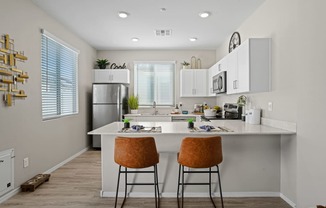 an open kitchen with a large island with two stools