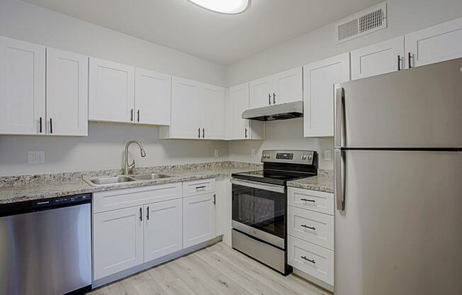 a kitchen with white cabinets and stainless steel appliances