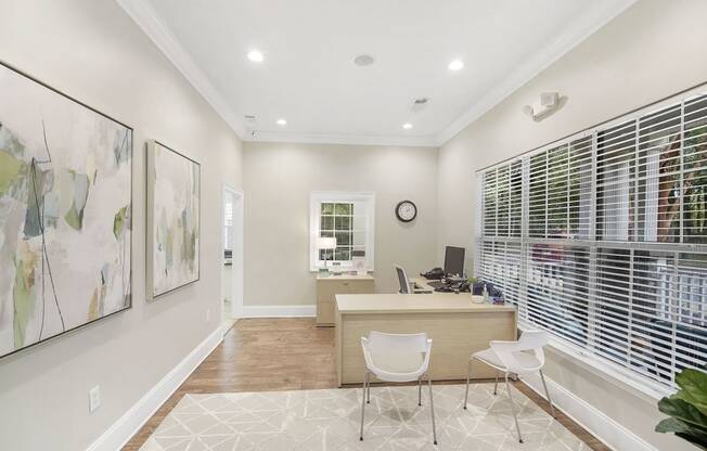 a home office with a desk and chairs and a large window