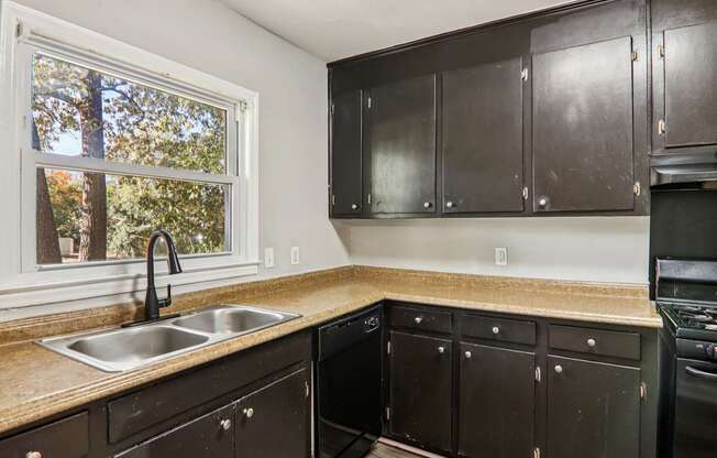 A kitchen with black cabinets and a window.