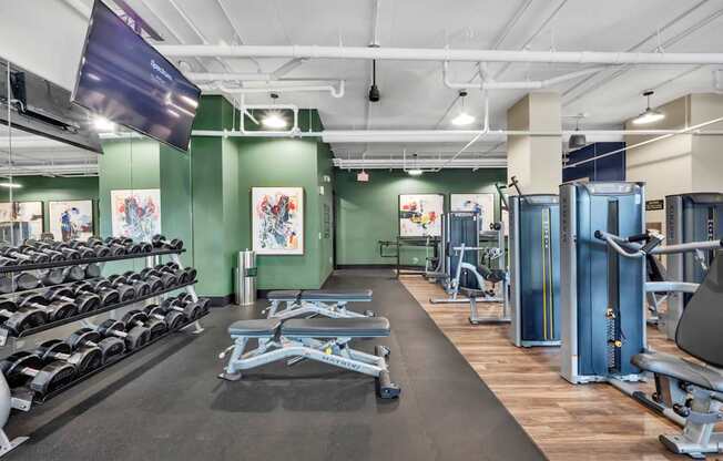 A gym with a variety of equipment including weights and machines.