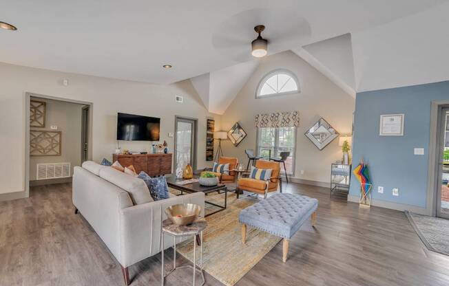 A living room with a white couch and a glass coffee table.