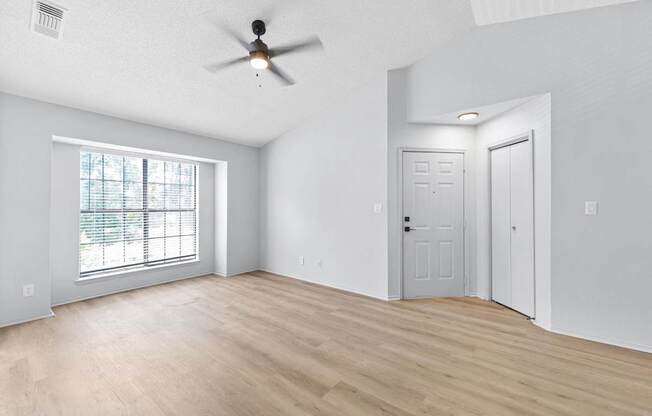 A room with a ceiling fan and two doors.