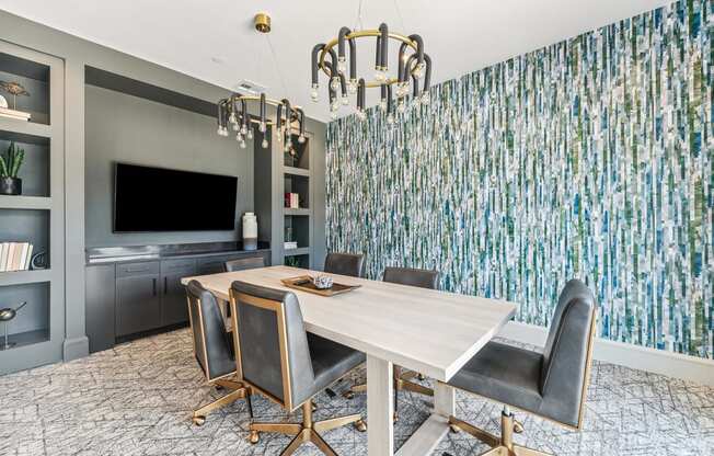 a dining room with a wooden table and chairs and a large wall mural of trees