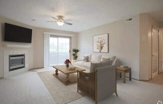 A living room with a fireplace and a flat screen TV mounted on the wall.