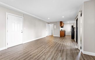 a bedroom with a medium sized bed and a kitchen in the background