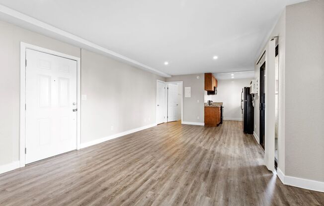 a bedroom with a medium sized bed and a kitchen in the background