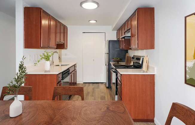 A kitchen with brown wooden cabinets and a white door at Heritage Grove Apartments in Renton, WA