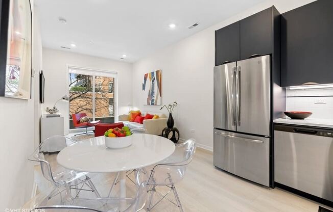 a kitchen with stainless steel appliances and a table and chairs