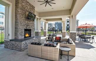 Covered Lounge with Cozy Fireplace by Pool at El Paso County Apartments Near I-25