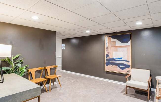 A room with a grey floor and a painting on the wall.