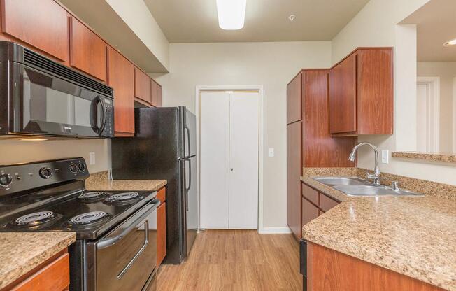 Galley-style kitchen with electric appliances and wood cabinets