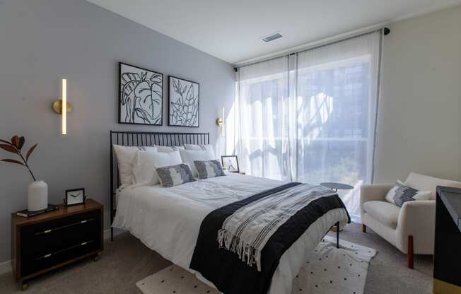 Maple Street Lofts - Bedroom with Two-Toned Paint, Bed, Dresser, Chair, Nightstand, and Window.