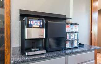 A coffee machine is on a counter with a display showing the word "coffee".