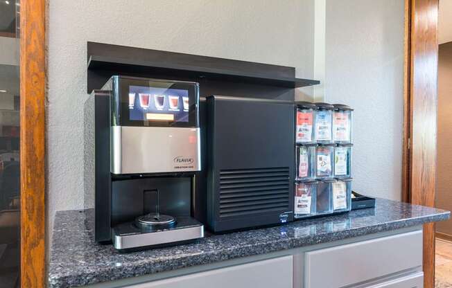 A coffee machine is on a counter with a display showing the word "coffee".