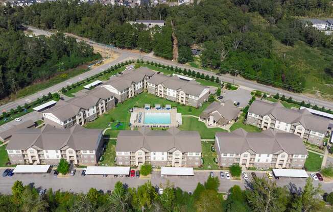 A large apartment complex with a swimming pool in the middle.