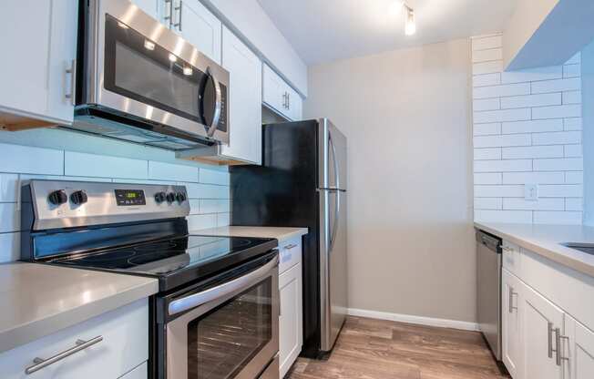 a kitchen with white cabinets and stainless steel appliances