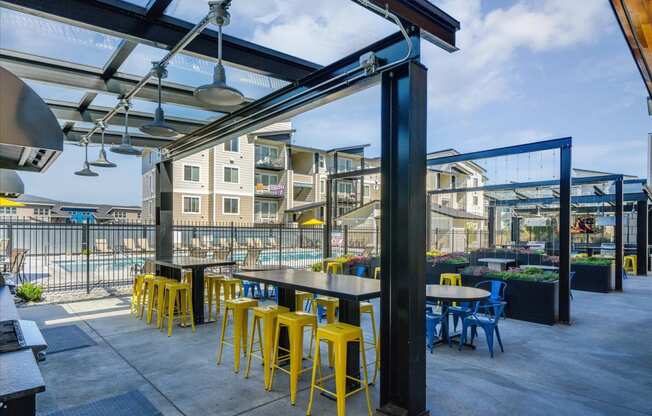 a patio with tables and chairs and a pool