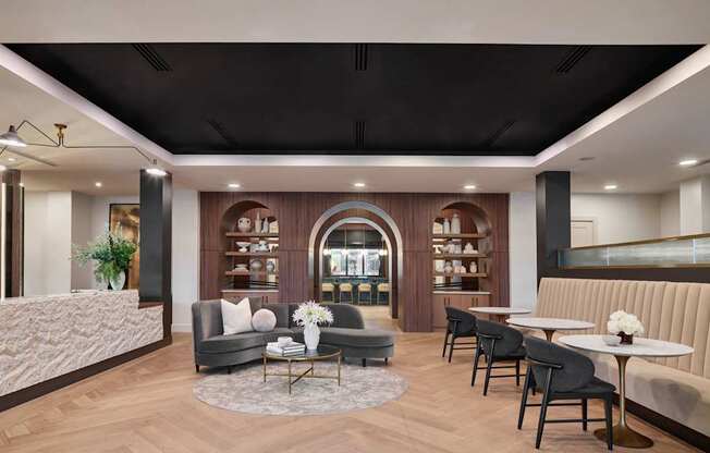 A modern living room with a grey sofa, a coffee table, and a bookshelf.
