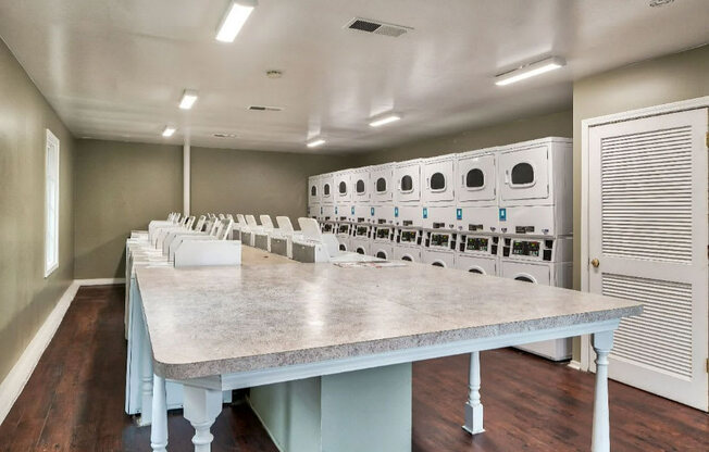 a large laundry room with a long table in the middle of it at Station JTown, Louisville