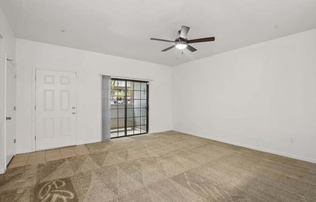 A room with a ceiling fan and a rug with a tree design on it.