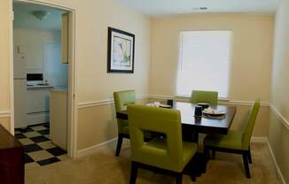 View of dining room model with square table and four green chairs