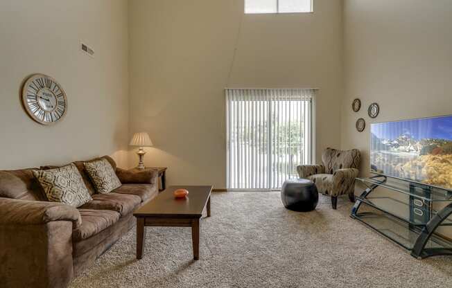 Large windows and sliding doors provide lots of natural lighting in the living space at Pine Lake Heights Apartments