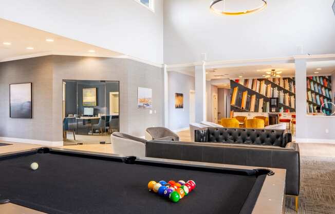a game room with a pool table and couches