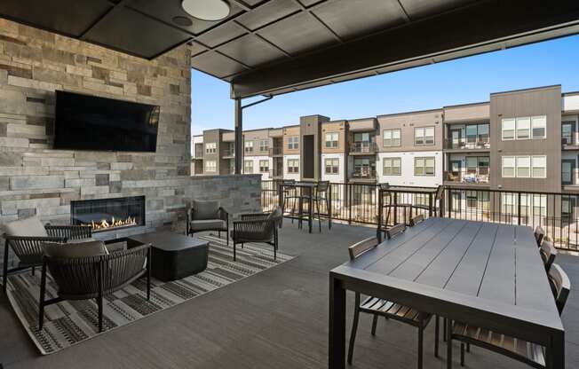 a patio with a table and chairs and a fireplace