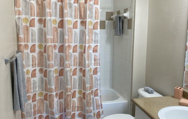 a bathroom with a shower curtain and a toilet and sink