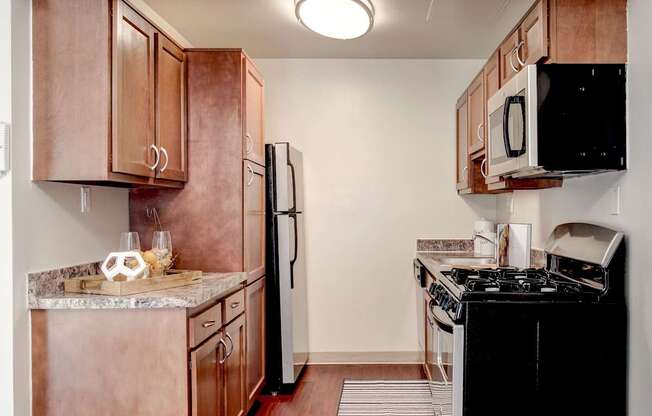 A kitchen with brown cabinets and black appliances.