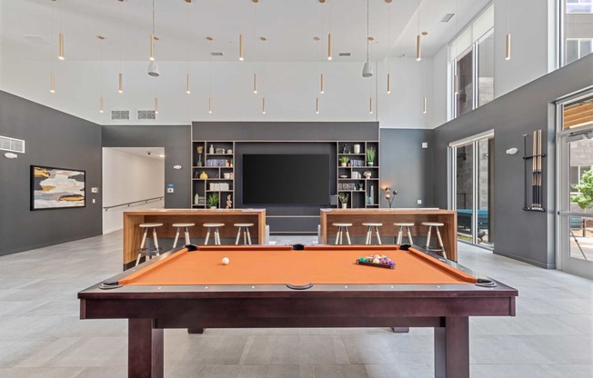 a games room with a pool table and a television