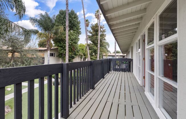 the view from the balcony of a house with a wooden deck