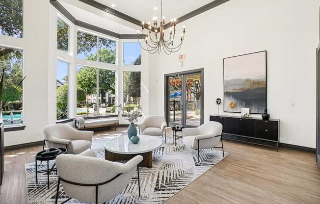 A living room with a large window and a chandelier.