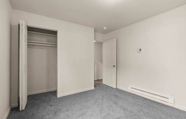 A room with a grey carpet and white walls.