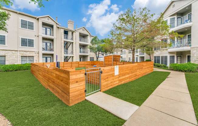 a wooden fence with a gate in front of an apartment building