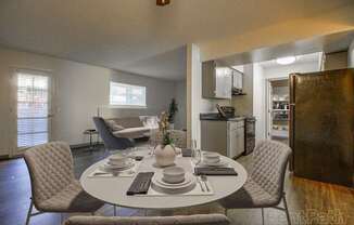 A dining room with a round table set for four.