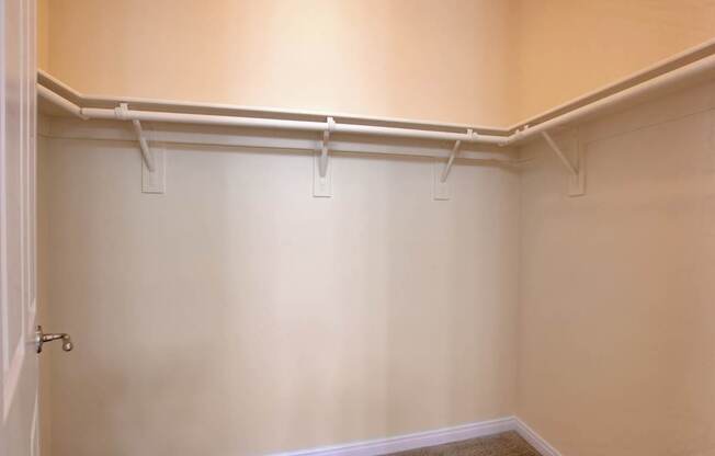 A white door with a handle is on the left side of a room with white walls and a white baseboard.