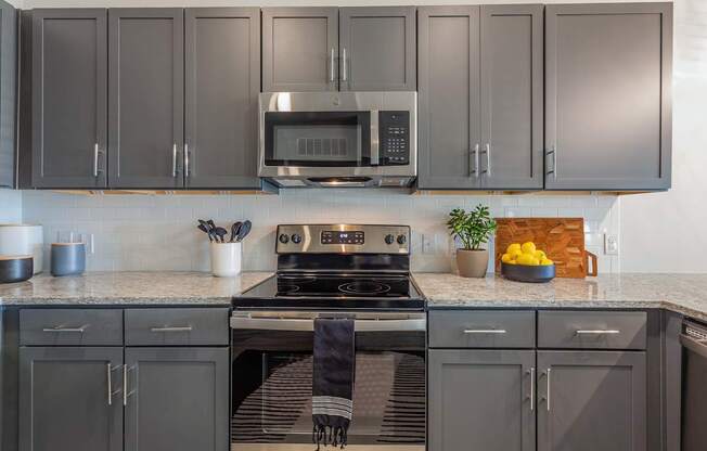 A kitchen with a stove, microwave, and cabinets.