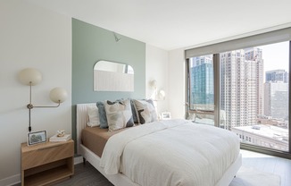 A bedroom with a large bed and a view of the city.