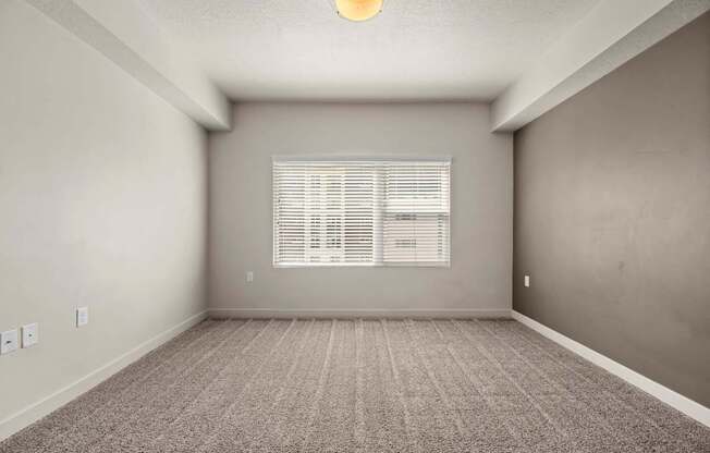an empty room with a large window and a carpeted floor at Wilmington Flats Apartments, Utah