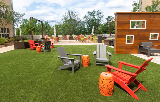 a lounge area with chairs and a fire pit on a lawn