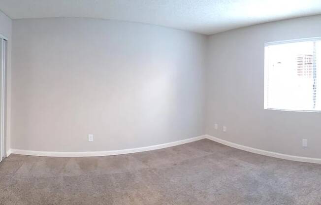 an empty room with white walls and a window