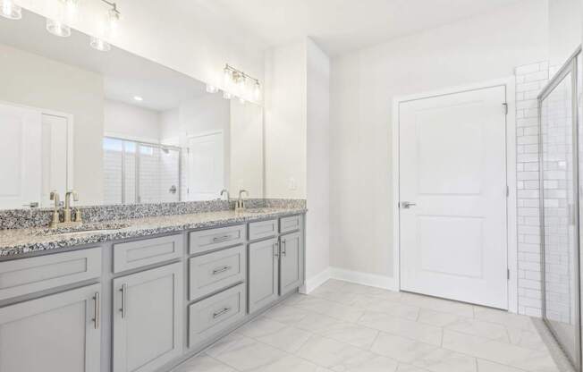 A bathroom with a vanity and a walk-in shower.