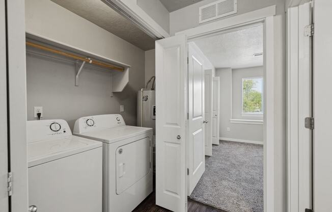 a washer and dryer in a laundry room with a window and a door